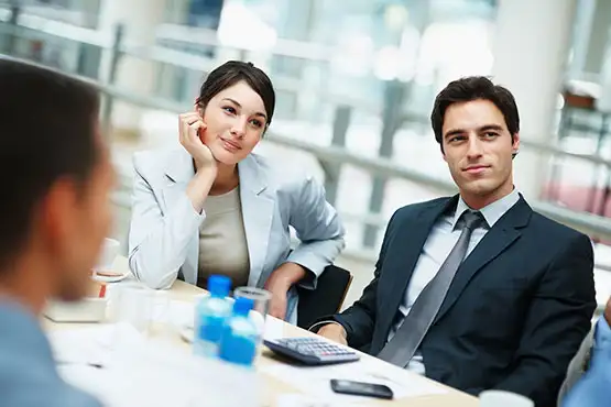 A group of business professionals in a meeting, focusing on a presentation or discussion.